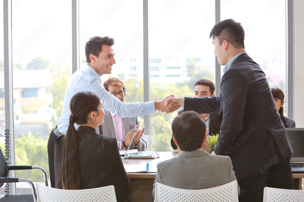 caucasian businessman showing success business profit graph from white board in meeting then they shaking their hands meaning of their job is success with smiling and happy faces. caucasian businessman showing success business profit graph from white board in meeting then they shaking their hands meaning of their job is success with smiling and happy faces.