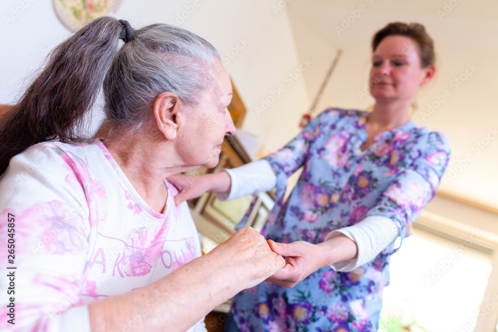 Obraz premium A young woman is holding the hand of an old woman