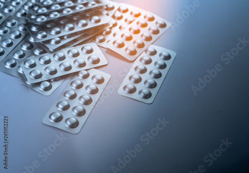 Pile of tablets pill in blister packaging to protect medicine from light. Silver aluminium foil blister pack. Pharmaceutical industry. Pharmacy products. Drug recall and withdrawal from market concept photo