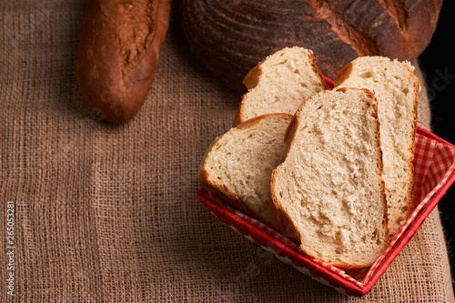 Top view of sliced wholegrain bread on dark ructic wooden background closeup