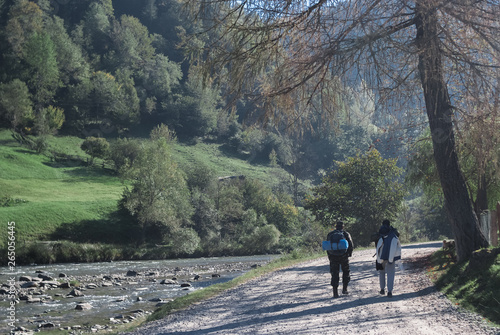 Two men walking near mountain river stream valley scenery landscape in summer day