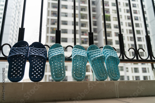 Slippers, washed and then dried in the sun in balcony of apartment building photo