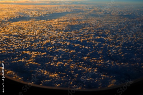 Top View of Clouds with Sunrise from Airplane Window.