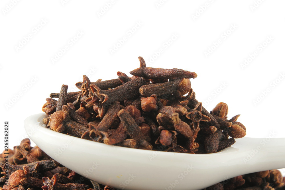 Obraz premium dried spice clove aromatic flower buds in spoon on white background