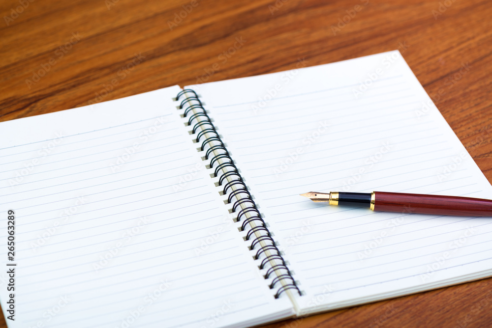 Fountain pen or ink pen with notebook paper on wooden working table with copy space, office desk concept. Fountain pen or ink pen with notebook paper on wooden working table with copy space, office desk concept.