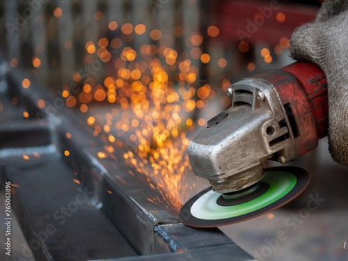 Close-up view of cutting steel shape, huge amount of sparks. Angle grinder sparks angle grinder cutting steel. Cutting steel with angle grinder. Worker cutting metal photo