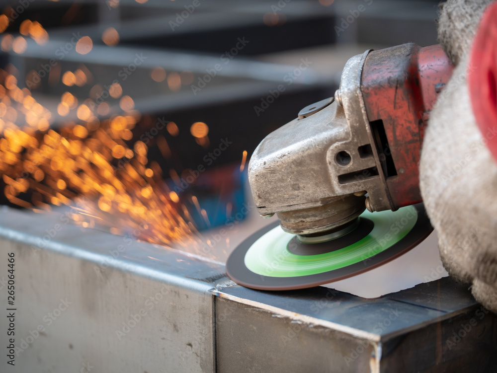 Close-up view of cutting steel shape, huge amount of sparks. Angle grinder sparks angle grinder cutting steel. Cutting steel with angle grinder. Worker cutting metal Close-up view of cutting steel shape, huge amount of sparks. Angle grinder sparks angle grinder cutting steel. Cutting steel with angle grinder. Worker cutting metal