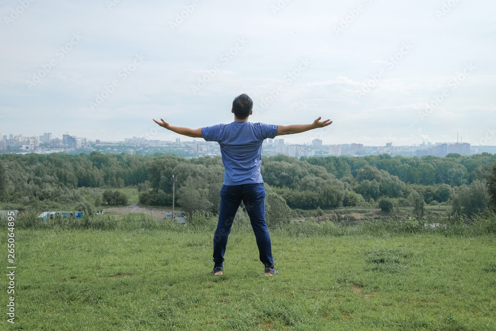 Korean man stretches against the background of the city. Healthy lifestyle. Adult man practicing yoga in nature. Korean man stretches against the background of the city. Healthy lifestyle. Adult man practicing yoga in nature.