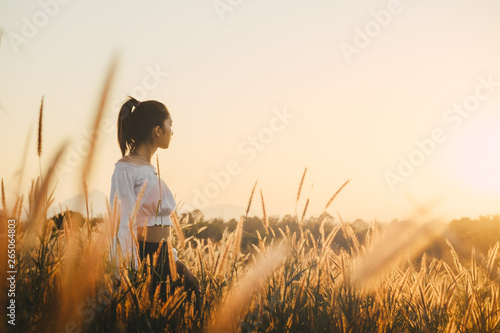 Beautiful young asian woman in a field with sunlight