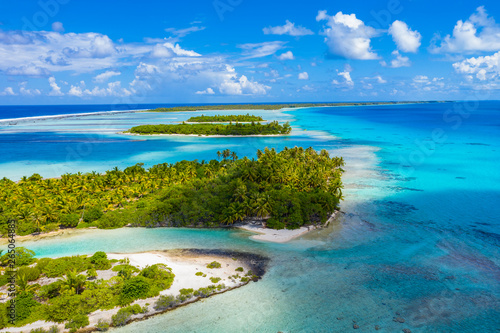 Drone aerial video of Rangiroa atoll island motu and coral reef in French Polynesia, Tahiti. Amazing nature landscape with blue lagoon and Pacific Ocean. Tropical travel paradise in Tuamotus Islands. photo