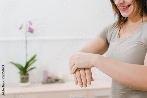 Closeup photo of female masseur stretching hands on the background of modern office