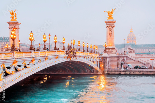 View on the Bridge of Alexandre III and and Les Invalides across Seine River in Paris at foggy night, France.