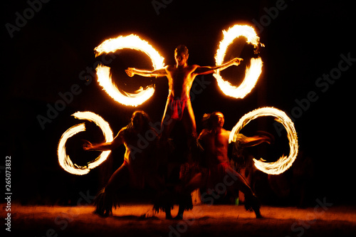 Luau Hawaii, French Polynesia fire dance silhouettes of professional dancers at night on beach resort tiki party. photo