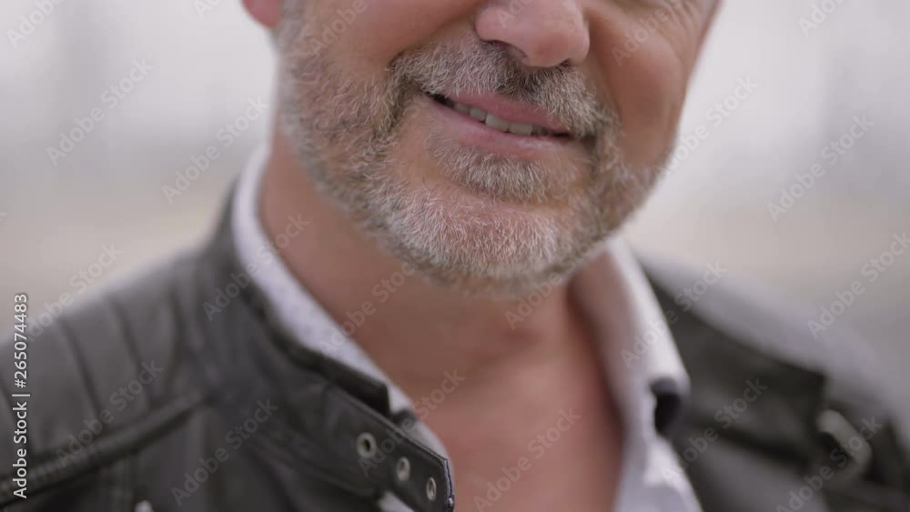 Cropped shot of smiling mature man. Close-up partial view of cheerful mature grey hair man laughing outdoor. Emotion concept Cropped shot of smiling mature man. Close-up partial view of cheerful mature grey hair man laughing outdoor. Emotion concept