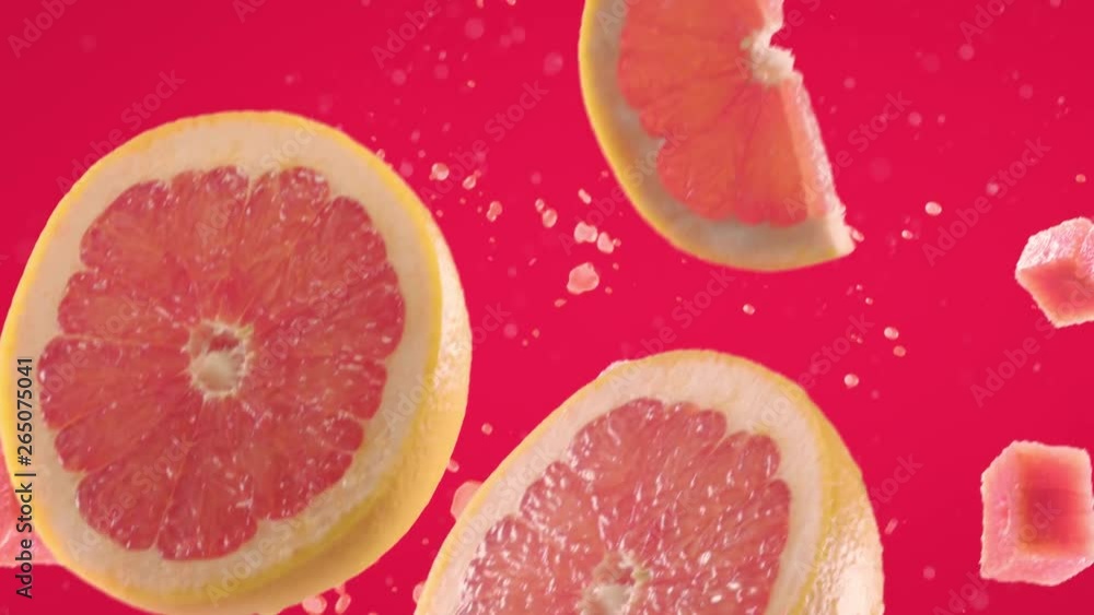 Grapefruit with Slices Falling on Fuchsia Background Grapefruit with Slices Falling on Fuchsia Background