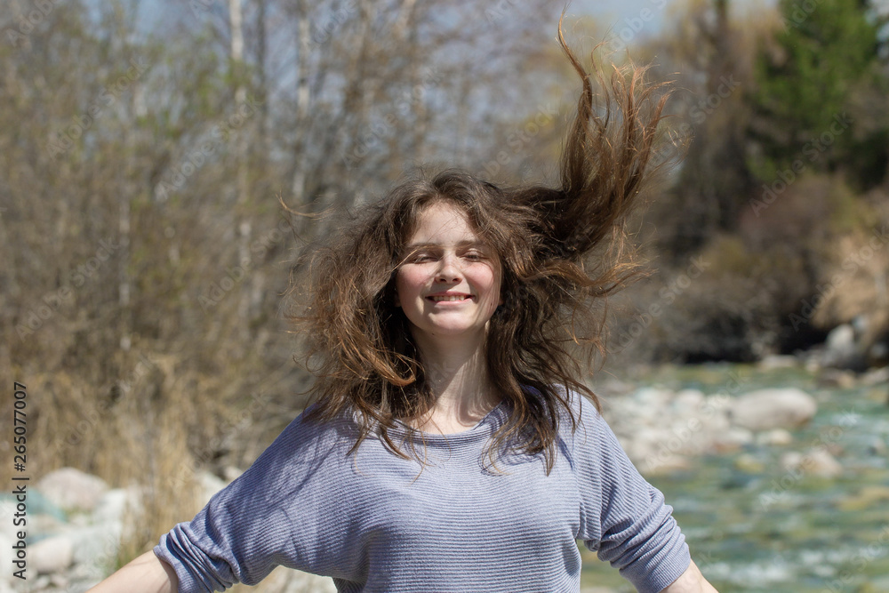 Young girl on nature with positive emotions. Relaxed, pleased with a smile on her face. Twists his head. Carefree fun pastime. Young girl on nature with positive emotions. Relaxed, pleased with a smile on her face. Twists his head. Carefree fun pastime.