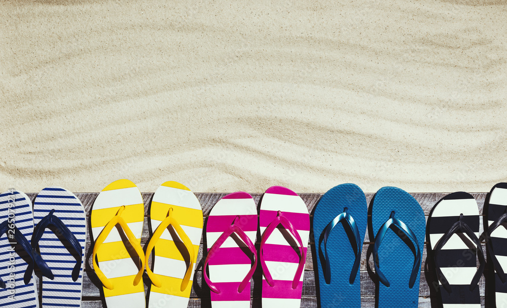 Naklejka premium Set of colorful flip flops on the beach deck