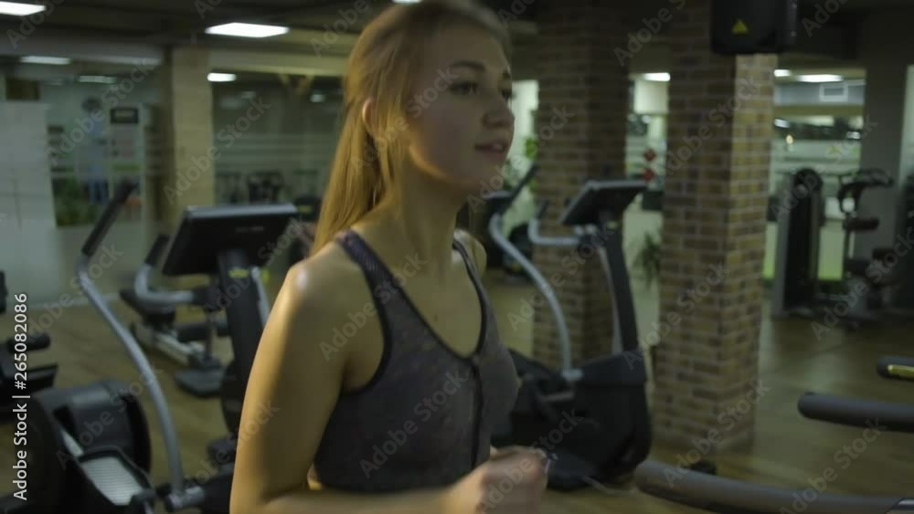 Beautiful girl engaged on a simulator in the gym on a black background Beautiful girl engaged on a simulator in the gym on a black background