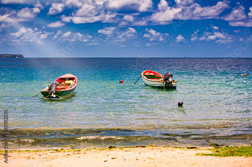 Small wooden colorful boats on clear water ocean