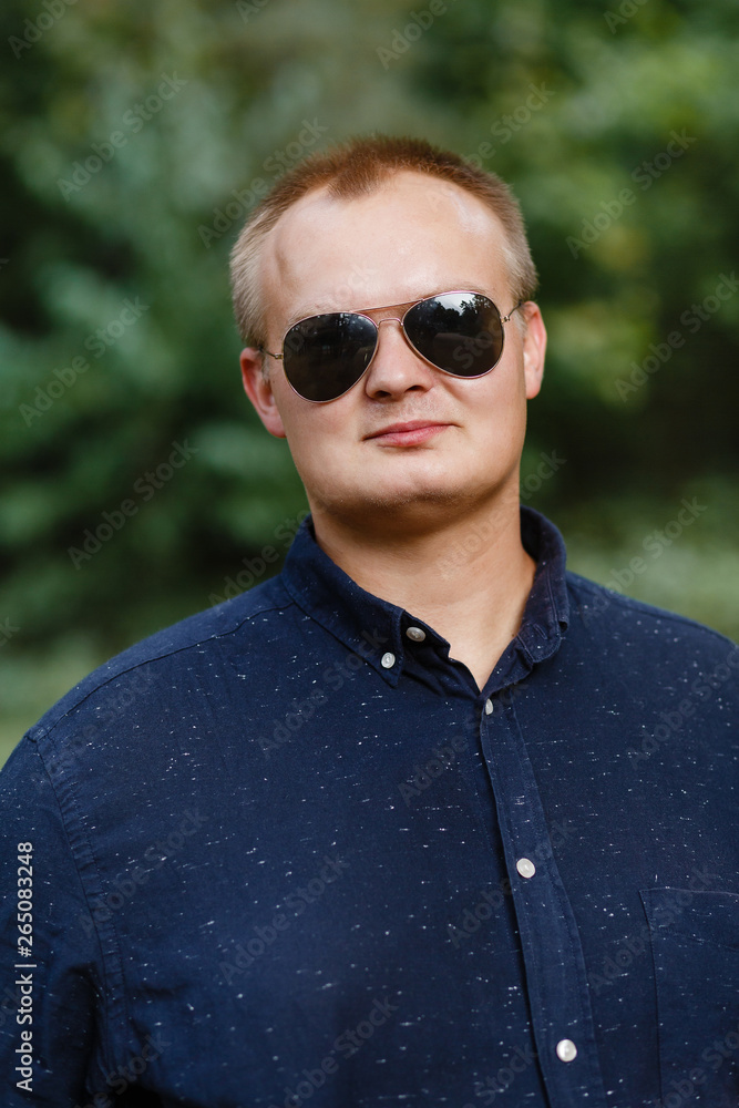 positive fat guy in sunglasses in a summer park positive fat guy in sunglasses in a summer park