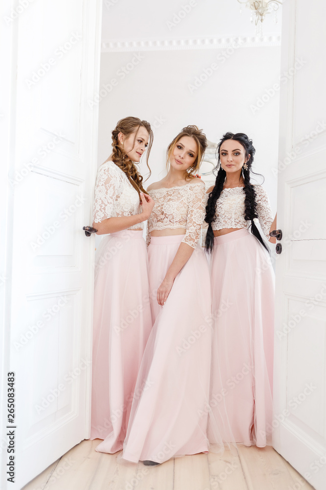 three bridesmaids smiling in a bright room at a wedding three bridesmaids smiling in a bright room at a wedding