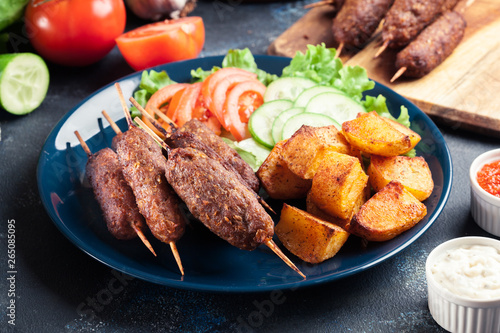Grilled shish kebab served with fried potatoes