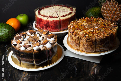 various cakes on display with dark background photo