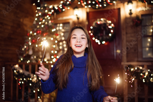 Portrait of a child girl looks with sparklers in their hands