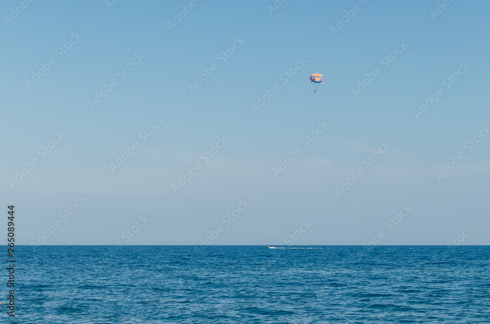 Parasailing is an extreme sport, people fly by parachute against the blue sky Parasailing is an extreme sport, people fly by parachute against the blue sky