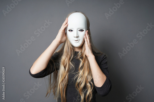 Fotografie mysterious young woman adjusting her mask with her hands