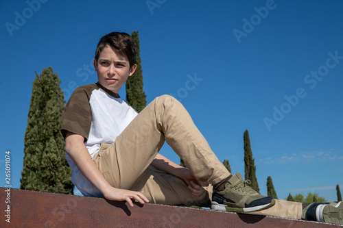 Quadro su tela Portrait of a 13-year-old boy with blue background sky