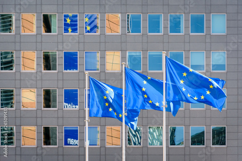 Three european flags blowing in the wind at full-mast in front of the Berlaymont building, headquarters of the European Commission, the executive of the European Union (EU) in Brussels, Belgium. photo