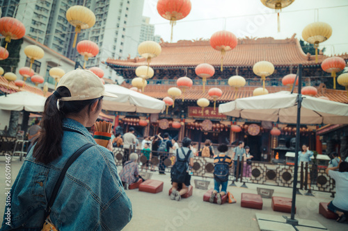 Girl pray at Wong Tai Sin Temple, New Kowloon in Hong Kong. Most famous Taoist temple exemplifies the architecture of a traditional Chinese temple. photo