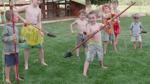 Slow motion of boys doing hawaiian haka chant with spears photo