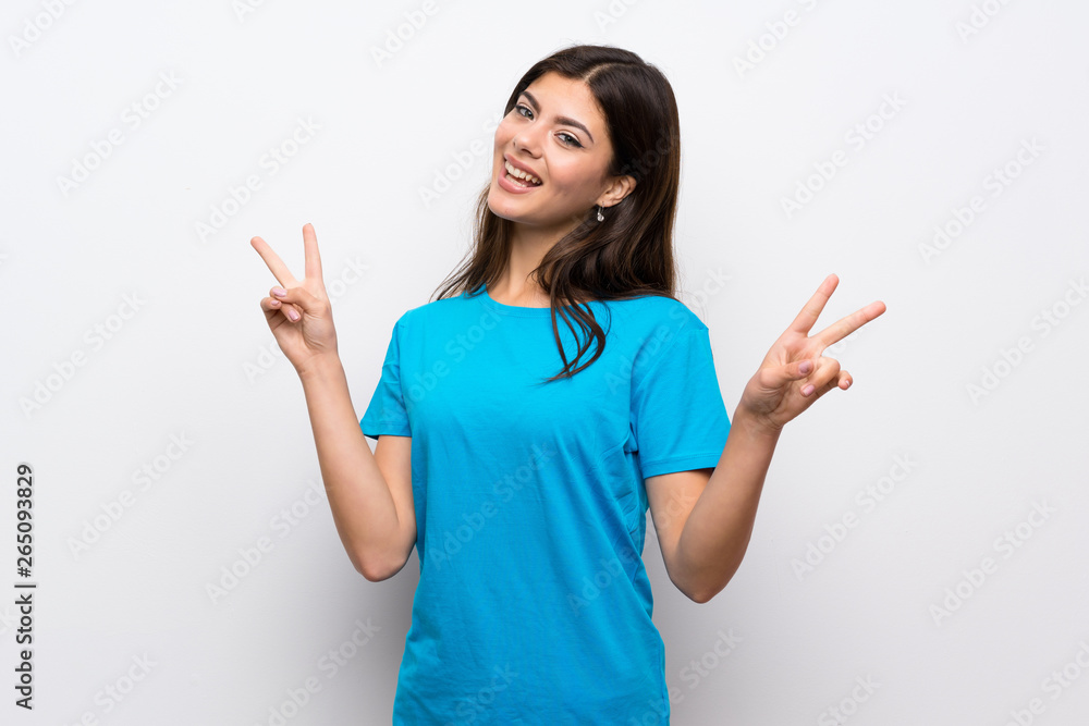 Teenager girl with blue shirt showing victory sign with both hands Teenager girl with blue shirt showing victory sign with both hands