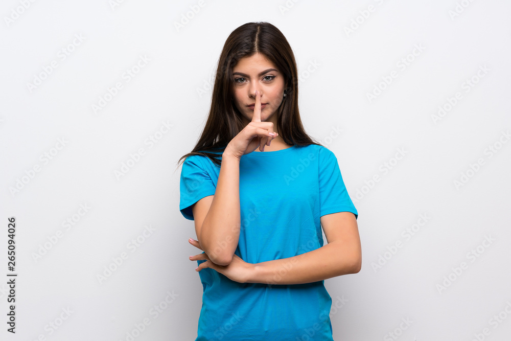 Teenager girl with blue shirt showing a sign of silence gesture putting finger in mouth Teenager girl with blue shirt showing a sign of silence gesture putting finger in mouth