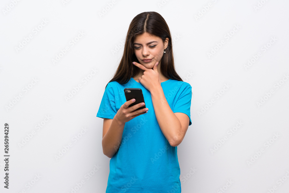 Teenager girl with blue shirt thinking and sending a message Teenager girl with blue shirt thinking and sending a message