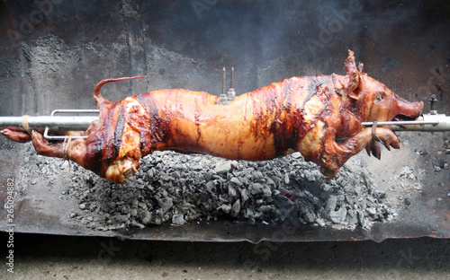 A piglet roasting at spit, traditional way, very tasty