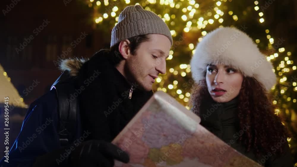 Couple with a map on a cold winter evening Couple with a map on a cold winter evening