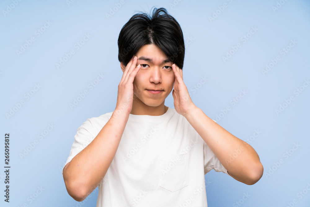 Asian man on isolated blue background unhappy and frustrated with something. Negative facial expression Asian man on isolated blue background unhappy and frustrated with something. Negative facial expression