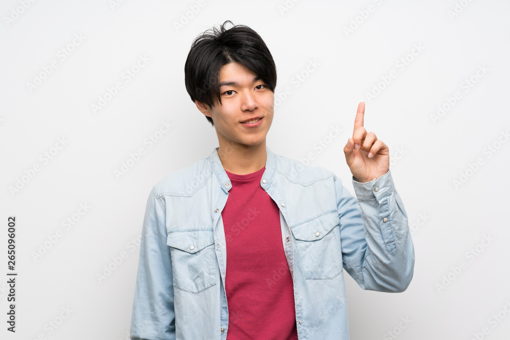 Asian man on isolated white background showing and lifting a finger in sign of the best Asian man on isolated white background showing and lifting a finger in sign of the best