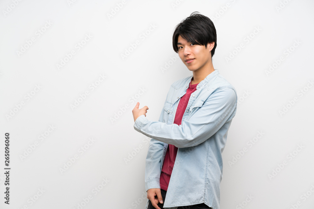 Asian man on isolated white background pointing back Asian man on isolated white background pointing back