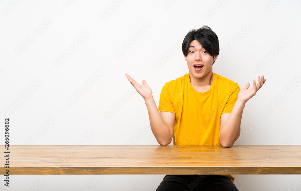 Asian man with yellow shirt with shocked facial expression Asian man with yellow shirt with shocked facial expression