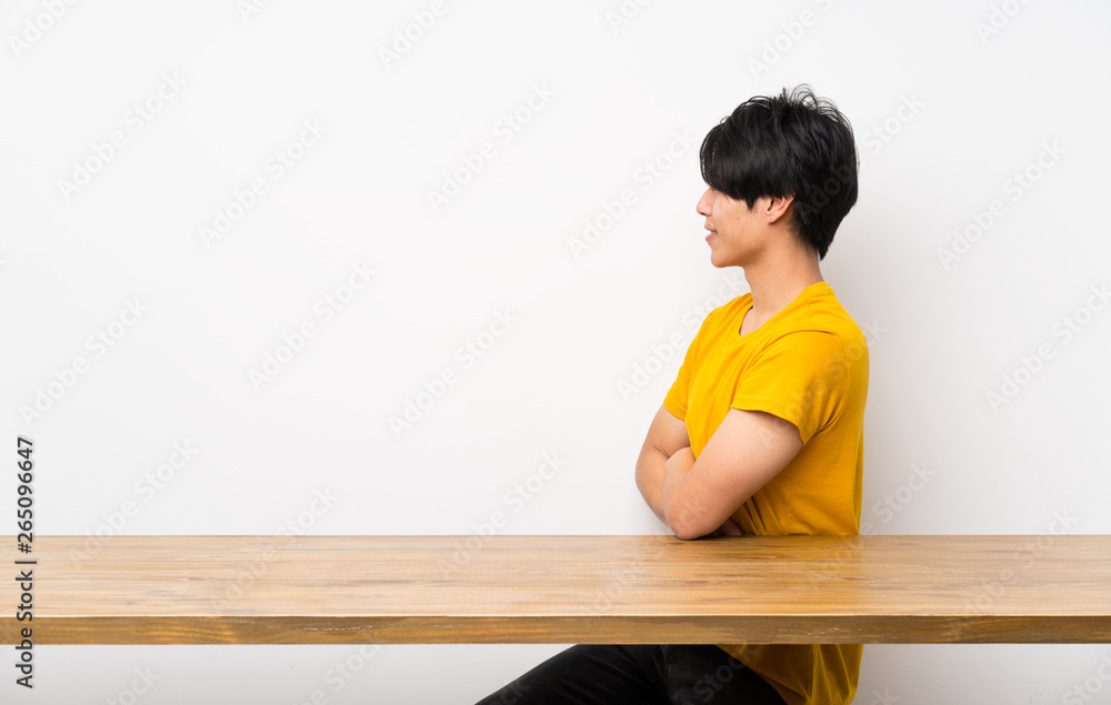 Asian man with yellow shirt in lateral position Asian man with yellow shirt in lateral position