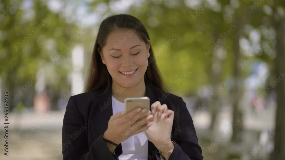 Girl using smartphone and walking on street. Beautiful young woman using mobile phone outdoor at sunny day. Technology concept Girl using smartphone and walking on street. Beautiful young woman using mobile phone outdoor at sunny day. Technology concept