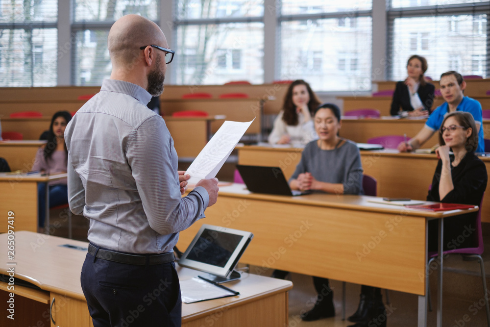 Lecturer and multinational group of students in an auditorium Lecturer and multinational group of students in an auditorium
