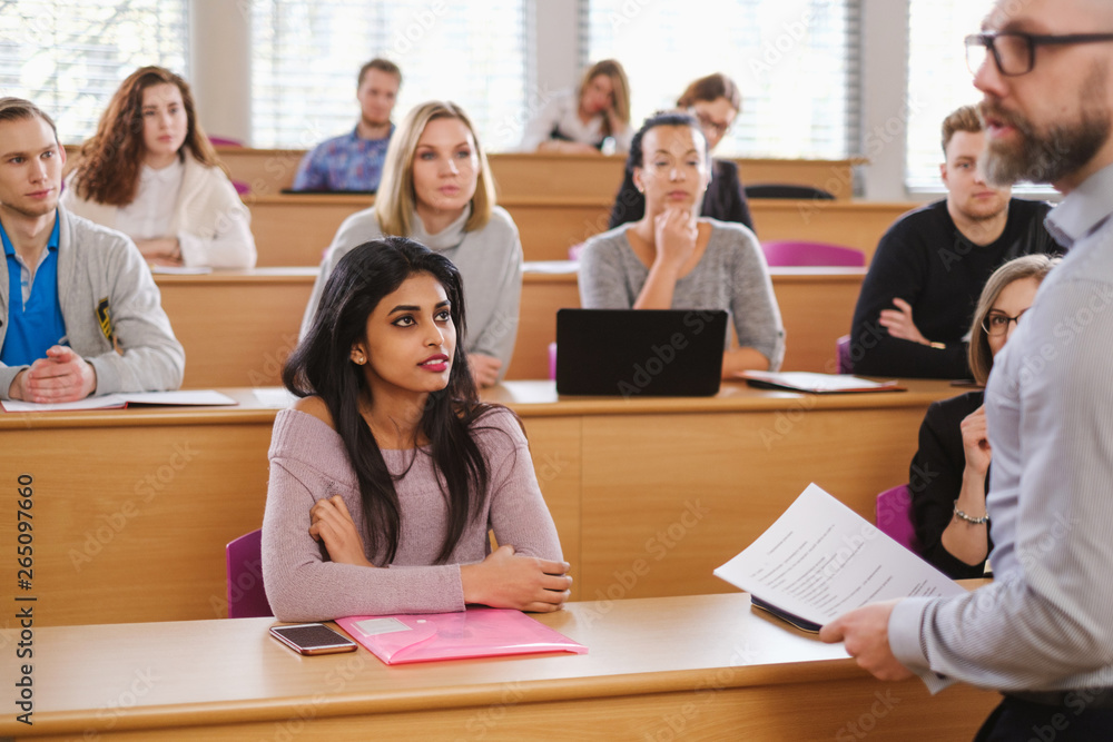 Lecturer and multinational group of students in an auditorium Lecturer and multinational group of students in an auditorium