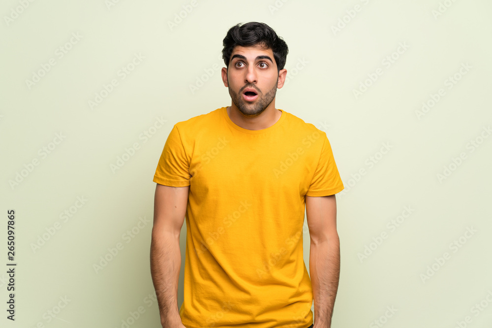 Young man over pink wall with surprise and shocked facial expression Young man over pink wall with surprise and shocked facial expression