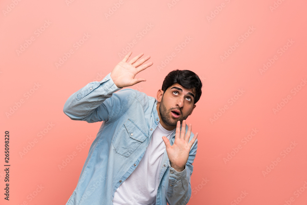 Young man over pink wall nervous and scared Young man over pink wall nervous and scared