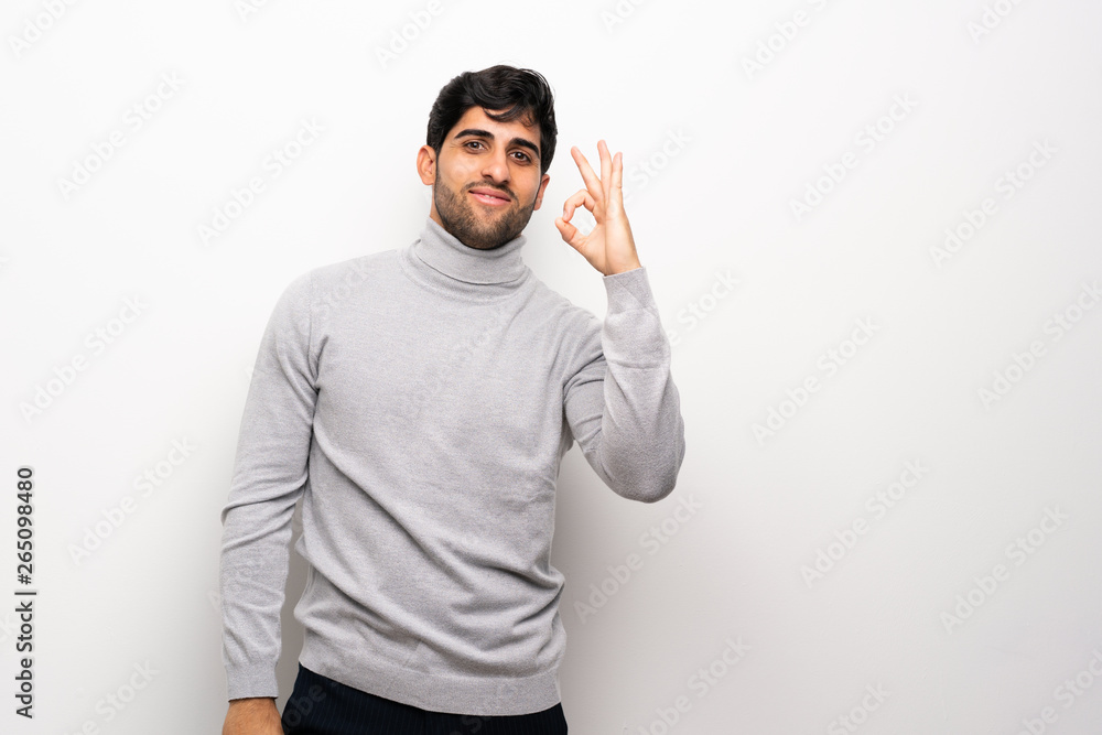 © luismolinero - Young man over isolated white wall showing ok sign with fingers © luismolinero - Young man over isolated white wall showing ok sign with fingers